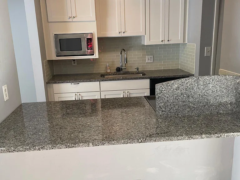 Updated Kitchen with Glass Tile backsplash and shaker cabinets.