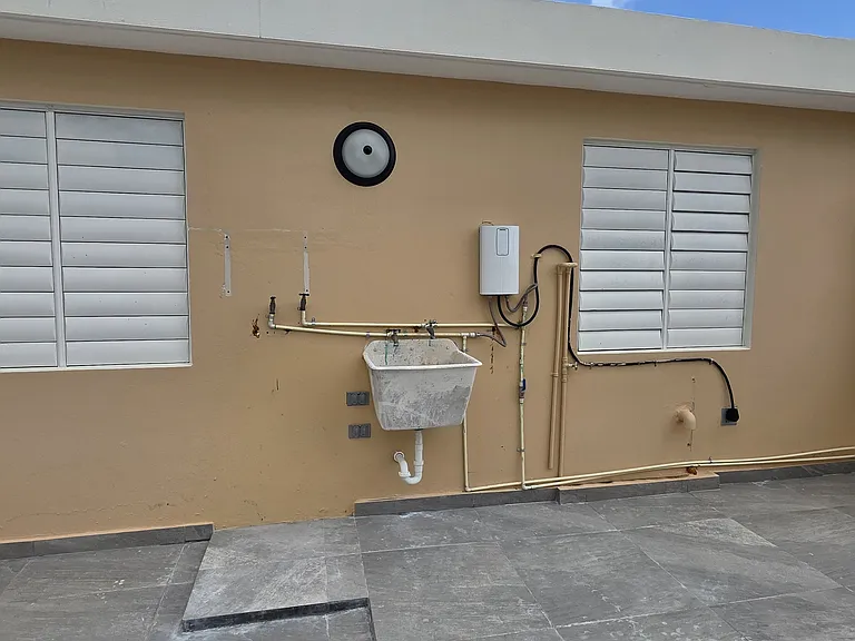 Laundry area with washer connections and a hot water heater.