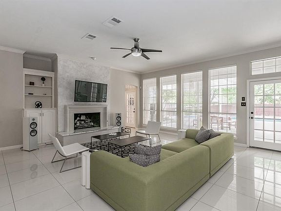 Living room features built in cabinets and a gas fireplace. Door to the right leads to covered patio.