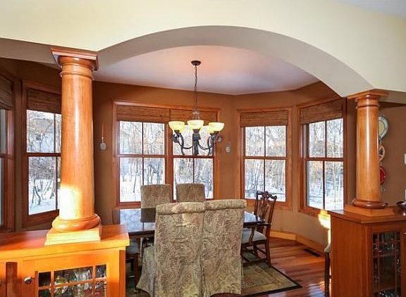 So many lovely details including columns, arches and built-ins. The dining area overlooks the beautiful backyard with windows  on all sides.
