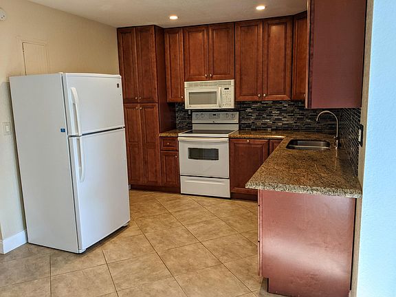 Functional kitchen with full-size fridge, stove, microwave, and dishwasher. Ample cabinet space and durable tile floors make meal prep and clean-up a breeze_ideal for daily living and easy maintenance.