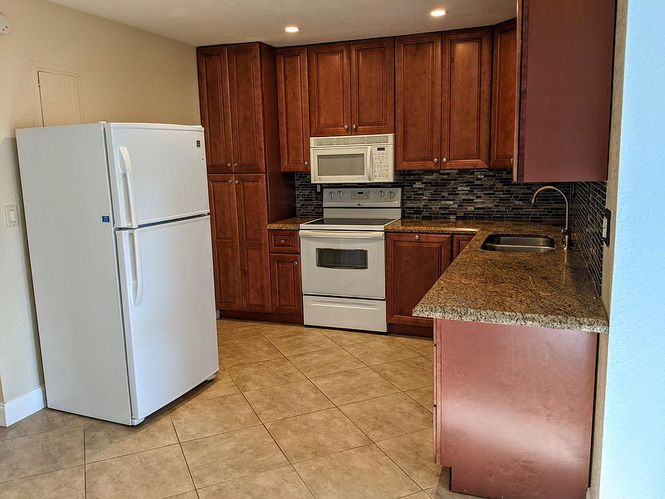 Functional kitchen with full-size fridge, stove, microwave, and dishwasher. Ample cabinet space and durable tile floors make meal prep and clean-up a breeze_ideal for daily living and easy maintenance.