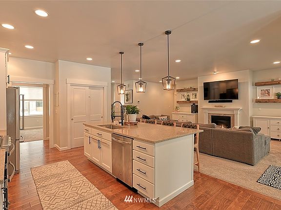 Light and bright kitchen with plenty of counter space, eating bar on the island and pantry. Opens to delightful living room with a cozy fireplace. 
