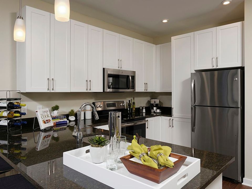 Open concept kitchen with granite countertops, white shaker cabinetry and stainless steel appliances