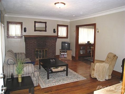 Open Living room with fireplace on main floor. Wood floors