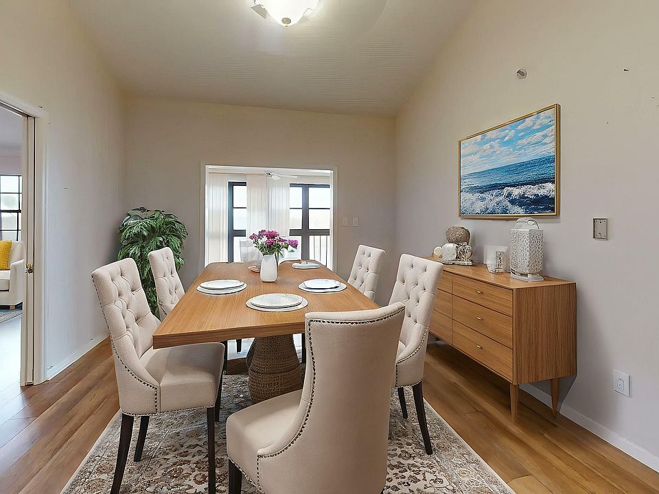Elegant dining room featuring a stylish wooden table set with plush chairs, adjacent to a cozy living area with vibrant decor, perfect for entertaining.