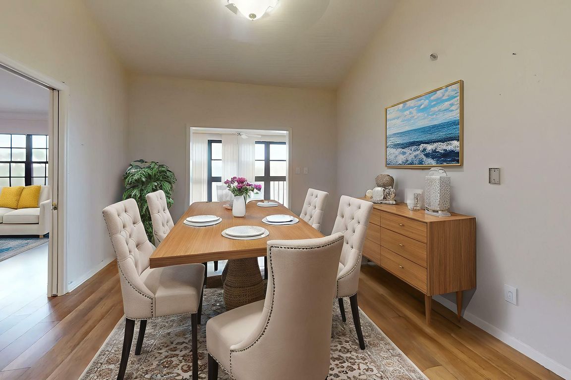 Elegant dining room featuring a stylish wooden table set with plush chairs, adjacent to a cozy living area with vibrant decor, perfect for entertaining.