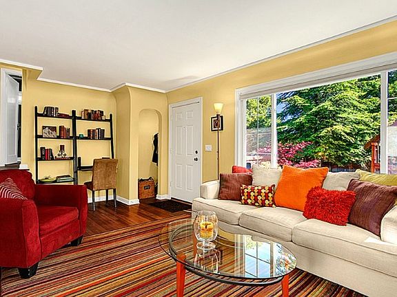 Light filled living room hardwood floors & period details overlooks beautiful front yard.