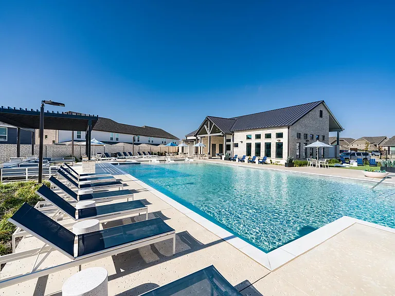 A resort-style pool at Amavi Celina features in-water loungers and generous deck space designed for relaxation.