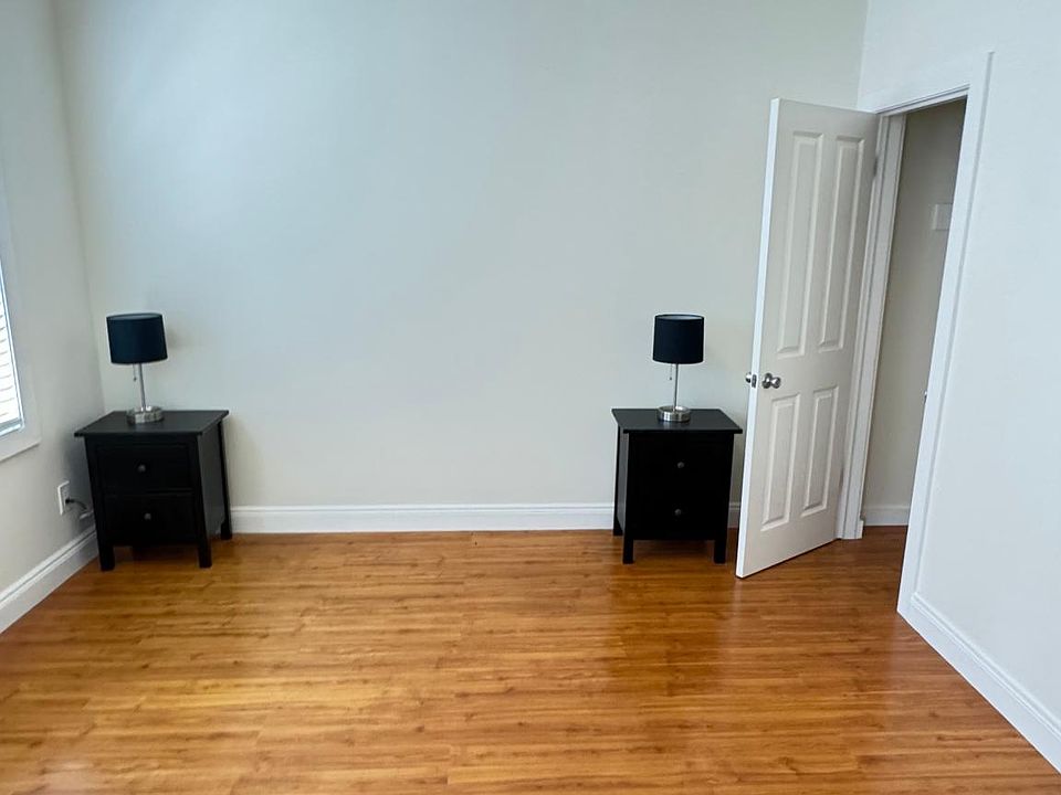 Spacious bedroom with 2 side table and a dresser. Door opens to spacious closet.