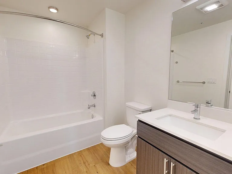 Apartment Bathroom with large soaking tub and wood-style flooring.