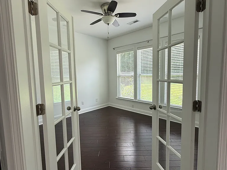 Versatile downstairs flex room with elegant French doors, beautiful hardwood floors, and extensive natural light."