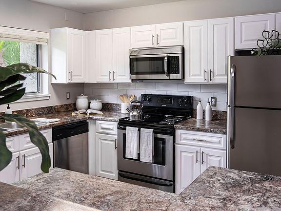 Cook in style with a fully equipped kitchen featuring stainless steel appliances, granite-style countertops, and ample cabinetry.