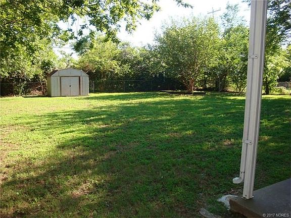 Nice shaded back yard with small storage shed.