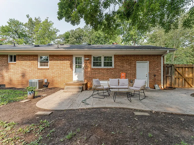 Back patio is stamped concrete, overlooking large private fenced backyard