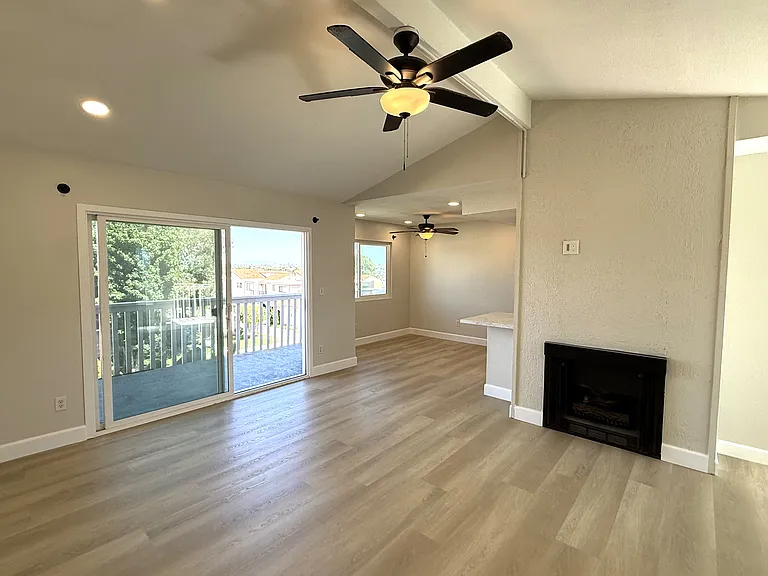 Living room with fireplace and adjacent balcony and dining room