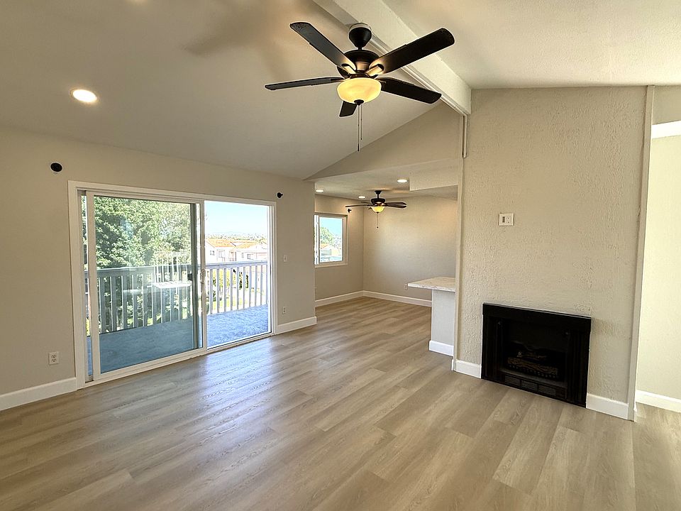 Living room with fireplace and adjacent balcony and dining room