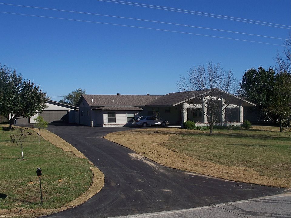 Ashalt drive leading up to the 3 car garage and 4 car carport