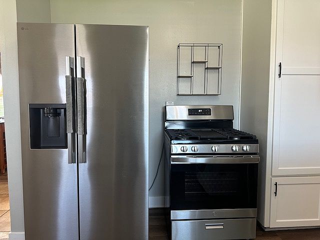 Refrigerator/freezer, gas oven (with build in griddle) and water heater cabinet.