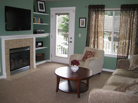Living room with gas fireplace and door to deck.