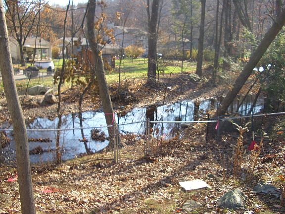 Fenced in back yard with Stream