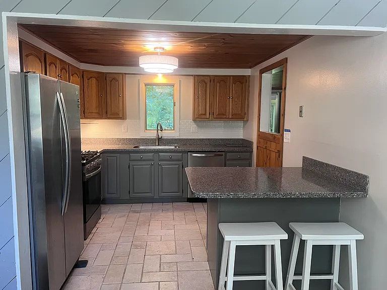 Newly renovated kitchen with stainless appliances including microwave/hood, dishwasher, fridge, oven. This is opposite dining room. Passthrough opening to living room to right.