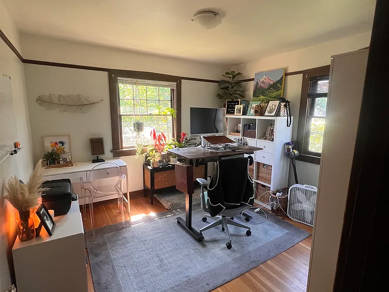 Front bedroom with a closet and two wardrobes. Natural light is let in by two large windows from daytime to evening.