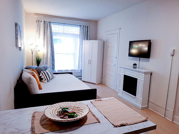 Bright Living area with Blackout Curtains, Daybed, Closet Fireplace, and Smart TV