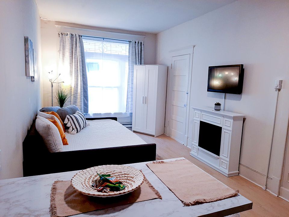 Bright Living area with Blackout Curtains, Daybed, Closet Fireplace, and Smart TV