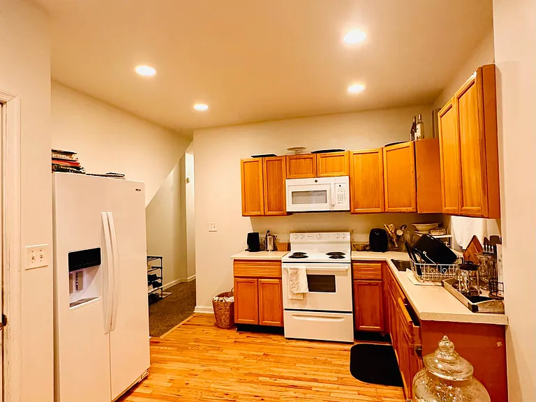 Open-concept living / kitchen space with new side-by-side refrigerator with ice maker