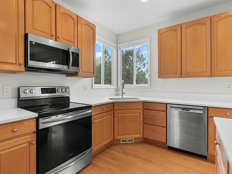 The kitchen offers stainless steel appliances, ample countertop space, and abundant cabinetry for storage and functionality.