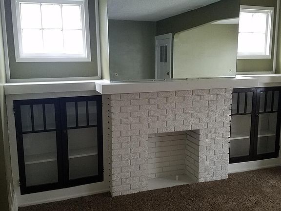 Lower fireplace, bookcases and recessed windows.