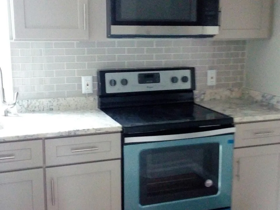 Brand new modern kitchen with granite and glass backsplash.