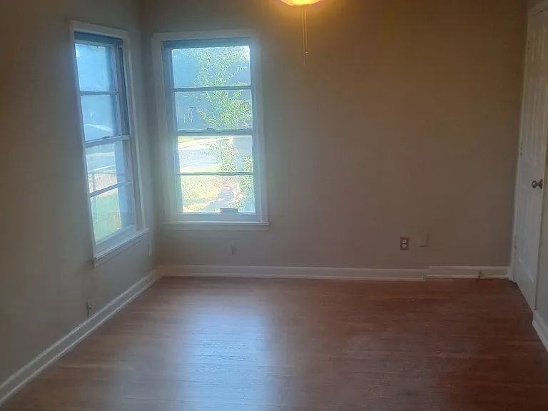 Master bedroom with original hardwood flooring, remodeled with ceiling fan.