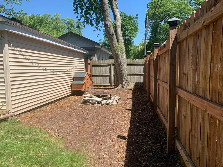 Backyard area with fire pit and chicken coop! Another great area for planting, gardening or entertaining. Brand new fence all around the property.