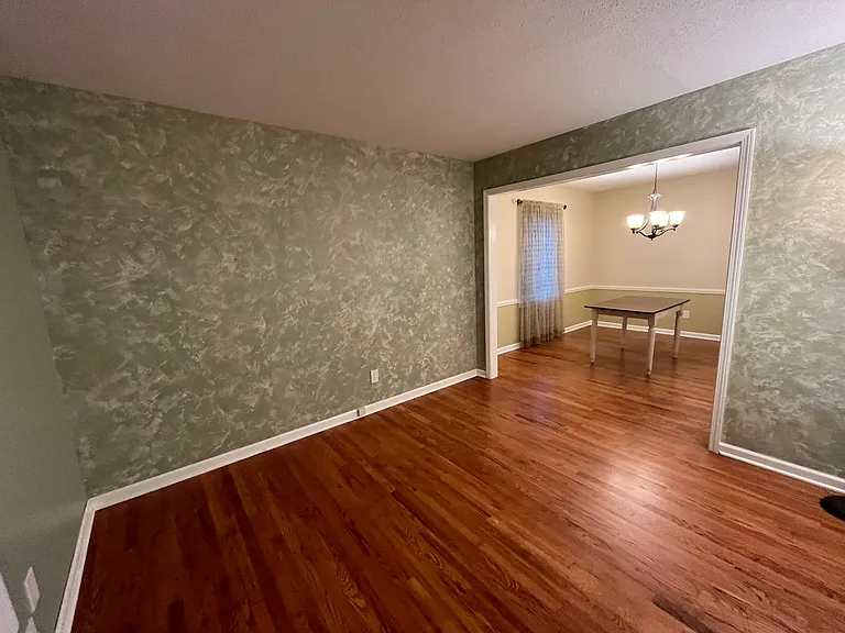 Living room. That is not wall paper - it is a wall treatment with a base green and a treatment over.