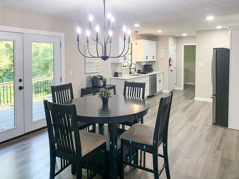 Eating area looking into the kitchen with pantry and laundry room at the far end . French doors to back deck