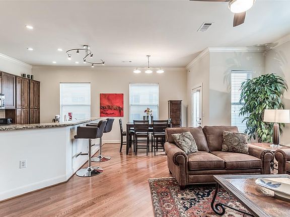 Open Living, Dining, Kitchen is sure to delight. Kitchen is separated by large island that has raised counter for barstools. Recessed lighting above Kitchen. While the plan is open, there are defined spaces for Dining in background and Living to righ