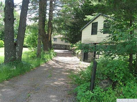 grand entrance with long driveway and garage close to the street