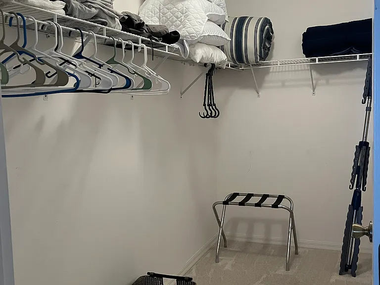 Primary bedroom closet: luggage rack, laundry baskets, drying rack, plenty of extra sheets, blankets and pillows