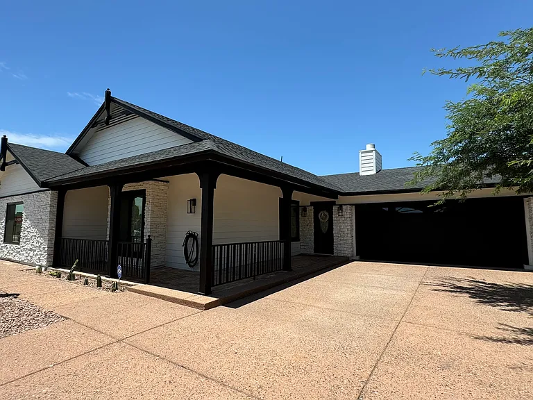 EXTERIOR. Street view. Property offers a two-car garage, covered porch and ample driveway.