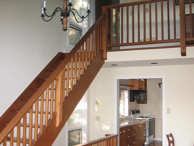 View of kitchen and upstairs balcony from the living room.