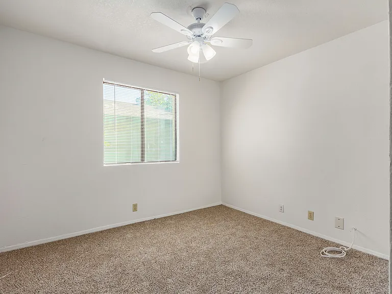 View of downstairs bedroom #1. New fan, paint, flooring, and mirrored closet doors.