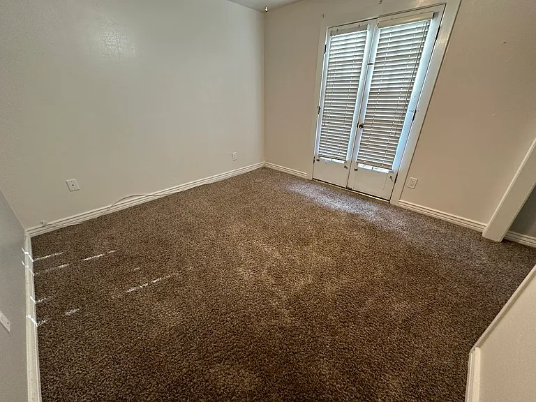 Bedroom off hallway with exit to private side patio