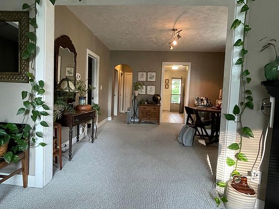 dining room with first bedroom on the left, hallway on the left to second bedroom, and kitchen on the right