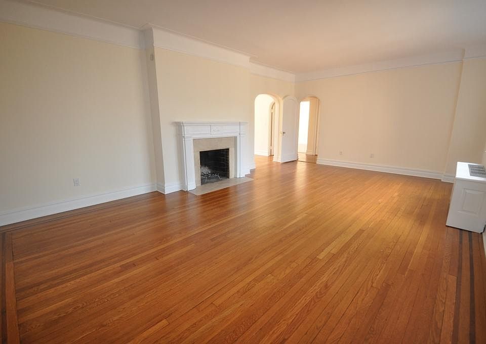 Large Living Room overlooks Garth Woods, has a working fireplace and refinished hardwood floors. Cove ceiling and arched doorways complete the look.