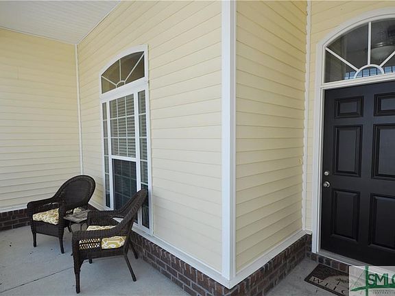 Sweet sitting area on your front porch overlooking a professionally landscaped garden