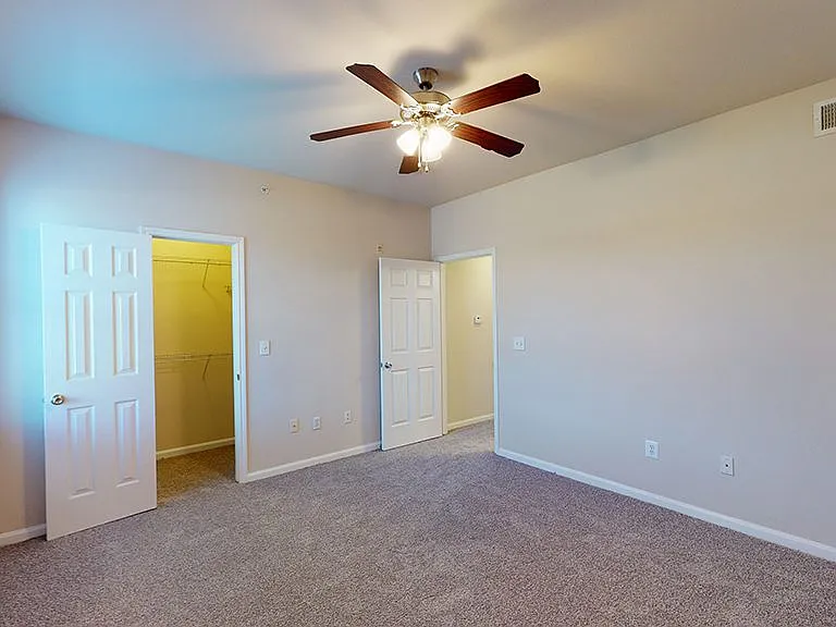 Spacious apartment bedroom with plush carpet flooring