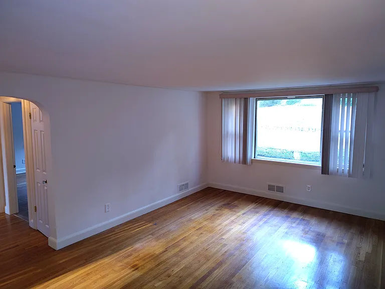 Dining/Living room area taken showing the front window and hallway to bedrooms.