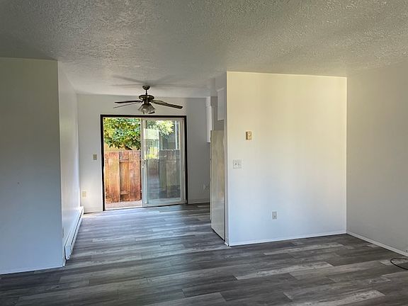 Picture from standing in the livingroom facing dining area/back sliding door/back fenced in yard, kitchen to the right, bedrooms and bathroom to the left